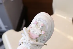 Dettaglio ravvicinato della punta di sneakers in pelle per bambini con charm mostriciattolo