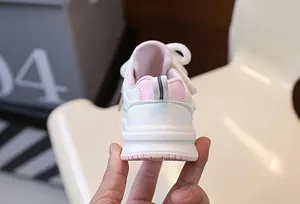 Dettaglio posteriore di scarpe da ginnastica bianche e rosa per bambine piccole