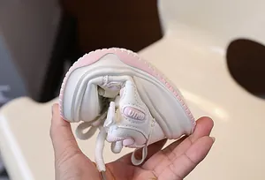 Dettaglio delle sneakers rosa e bianche per bambini con suola in gomma flessibile e morbida