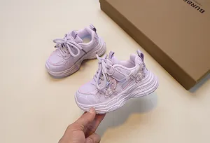 Close-up of girls purple sneakers featuring breathable mesh and pearl butterfly details