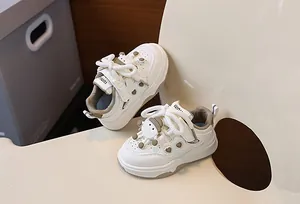 Dettaglio scarpe da ginnastica bimbi color crema con cuori e charm cartone animato 3D