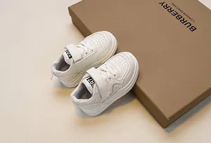 Close-up of kids white sneakers featuring velcro straps and breathable toe perforations