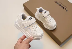 Detailed macro view of white kids' sneaker with velcro strap and blue wave design
