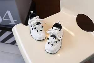 Dettaglio scarpa bianca per bambini con figura 3D nera e trama in morbida pelle