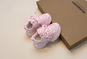 Close-up of pink girls sneaker with breathable mesh and pearl bow decoration