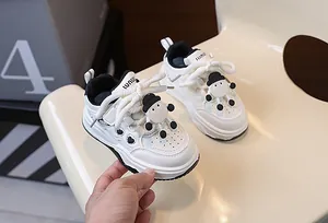 Dettaglio di sneaker bianche per bambini con cuori neri e decorazioni a forma di agnello