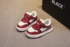 Detail of red and white kids sneakers showing breathable faux leather and velcro straps