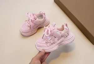 Detail of pink girls sports shoes featuring decorative butterflies with pearls and mesh