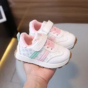 White children's sports sneakers with pink and green accents and smiley pattern