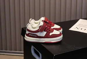 Close-up of kids' red and white sports shoes with Velcro strap and SPORTCHAO logo