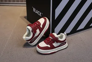 Detail view of burgundy and cream kids sneakers with velcro straps and breathable toe box