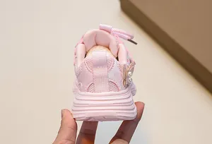 Detailed back view of pink girls sneaker with bow decoration and pearl accents