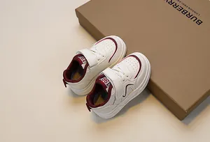 Top view of cream and burgundy children's sneakers with hook-and-loop closure