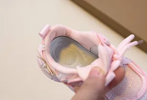 Detailed macro view of the padded collar and breathable mesh lining of the pink girl shoe