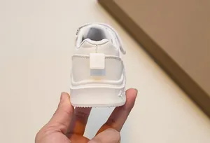 Detailed back view of off-white kids sneakers featuring heel pull tabs and velcro closure