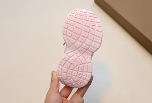 Close-up of pink non-slip rubber sole for toddler shoes with size 23 mark and grid patterns