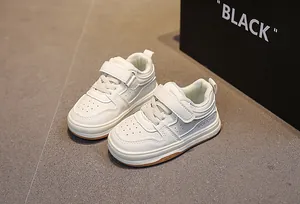 Close-up of white toddler sneakers featuring velcro straps and breathable toe vent details