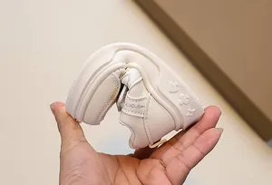 Detailed shot showing the flexible soft sole and embossed patterns on children sneakers