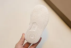 Detail of white rubber sole for kids sneakers featuring star non-slip grip pattern
