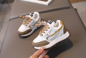 Macro detail of toddler sneakers featuring white and brown leather panels and anti-slip sole