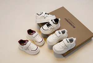Kids minimalist white sneakers with velcro straps and breathable holes shown on box