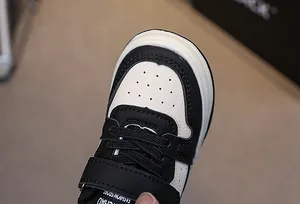 Detail view of the breathable perforated toe and velcro closure on these kids sneakers