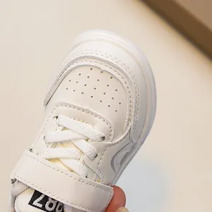 White children's leather sneakers with breathable toe holes and velcro strap