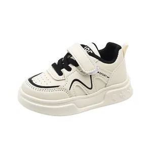 Kids cream white sneakers with black stripe details and velcro closure for active play