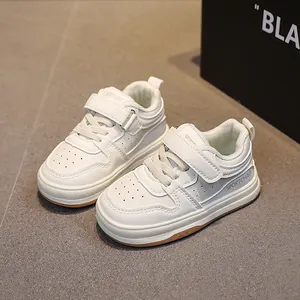Classic white children's sports shoes with velcro straps and anti-slip rubber soles