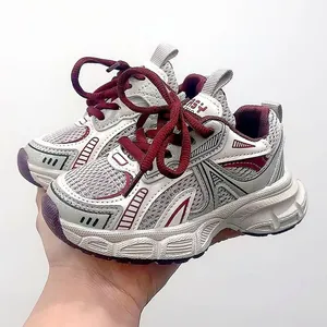 Close-up of kids mesh sneakers with burgundy laces and thick soles in grey and white