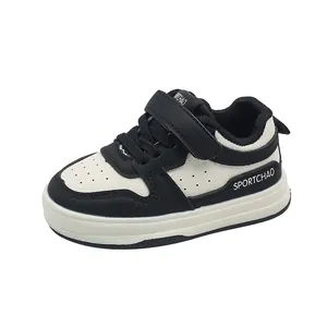 Classic black and white children sneakers with hook and loop closure and leather upper