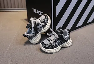 Dettaglio di sneaker in mesh per bambini con patchwork nero e grigio e suole antiscivolo