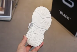 Detailed view of the anti-slip rubber sole on white girls sneakers with size 26 marking