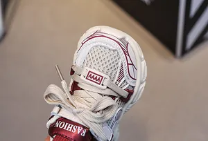Dettaglio in primo piano della maglia e pelle bordeaux su sneakers per bambini