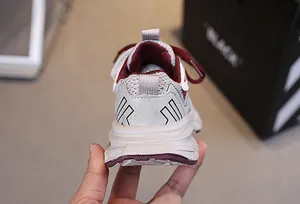 Detailed view of the gray breathable mesh heel with a stylish red accents on kids shoes