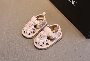 Dettaglio sandali rosa per neonata con coniglietto di paillettes e pizzi bianchi