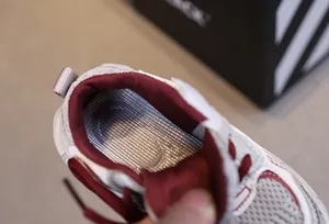 Detail of breathable mesh upper with silver grid insole and wine red inner lining
