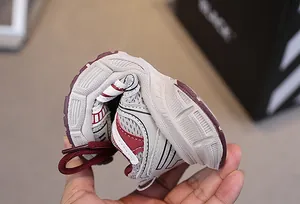 Close-up of highly flexible cream mesh kids' sneaker showing its extreme sole flexibility