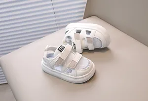 Detail of white summer toddler shoes featuring breathable mesh and dual velcro straps