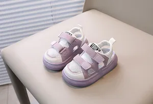 Close-up of purple and white mesh kids sandals with dual velcro straps on a chair