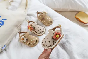 Gros plan de sandales bout fermé pour bébé avec fleurs et motifs à pois mignons