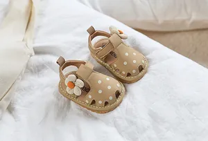 Détail d'une sandale bébé avec pois, fleur blanche et fermeture velcro pour tout-petits