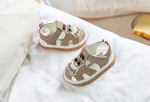 Vue détaillée des sandales bébé kaki avec ours 3D et sangle rayée rouge et verte