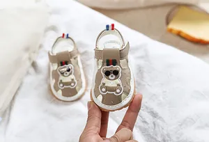 Détail de sandale bébé avec motif d'ours et fermeture à scratch pratique et rapide