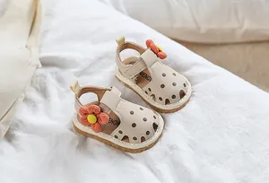 Vue détaillée de dessus des sandales bébé beiges à pois avec fleur en tissu orange