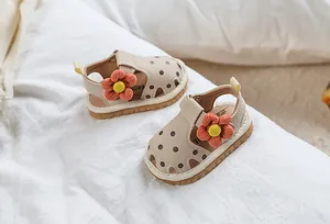 Détail de sandales pour bébé avec fleur en tissu orange et protection des orteils