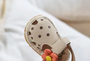 Gros plan détaillé d'une sandale d'été pour bébé avec une fleur décorative orange