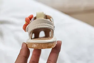Détail de sandales bébé fille en similicuir beige avec semelle en caoutchouc antidérapante