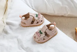 Pink toddler summer sandals with cherry decor and heart cutouts on white fabric