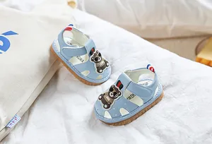 Détail de sandale bébé bleu clair avec motif ours et semelle en caoutchouc antidérapante